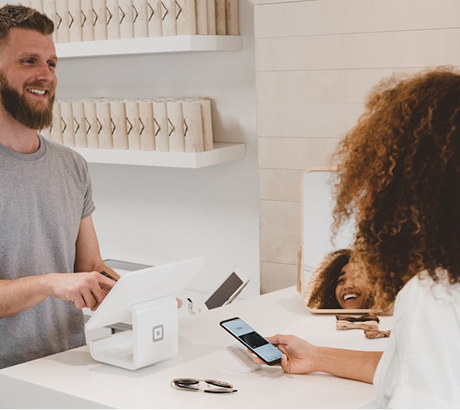 A person paying at a modern retail checkout counter.